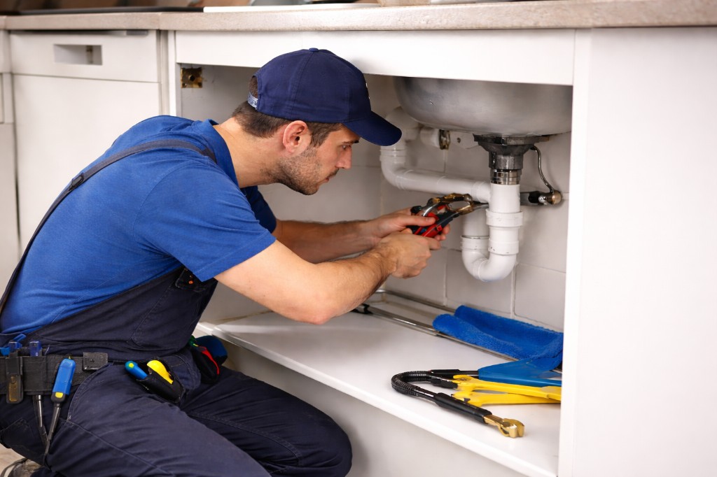 Canalizador a reparar uma instalação doméstica